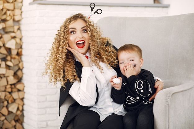 Free photo mother with child in costumes and makeup. family prepare to celebration of halloween.