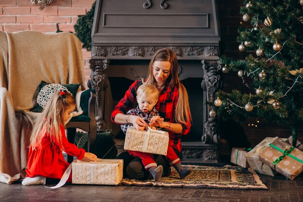 Mother with children by Christmas tree