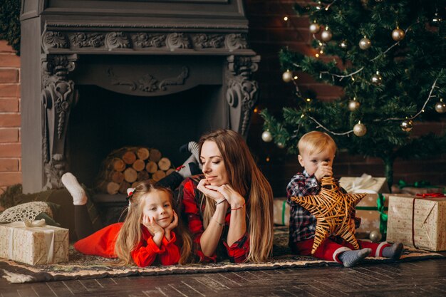 Mother with children by Christmas tree