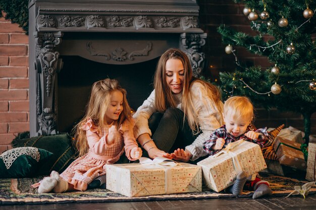 Mother with children by Christmas tree