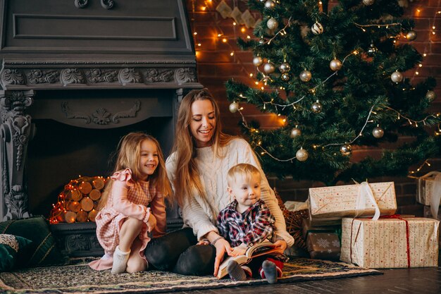 Mother with children by Christmas tree