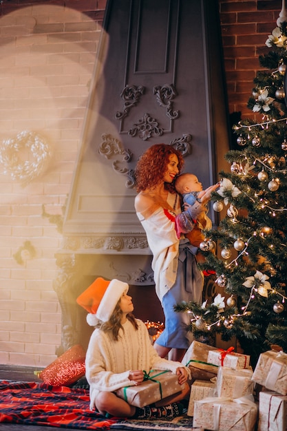 Mother with children decorating Christmas tree