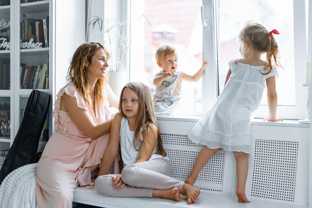 mother with children in a homely atmosphere. children by the window