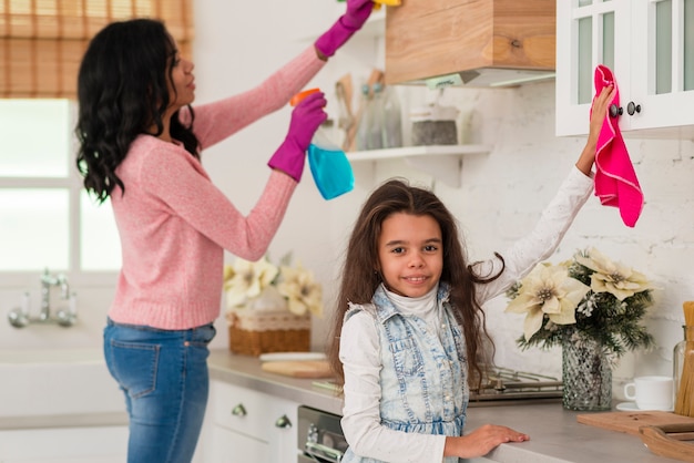 Mother with daughter cleaning the house