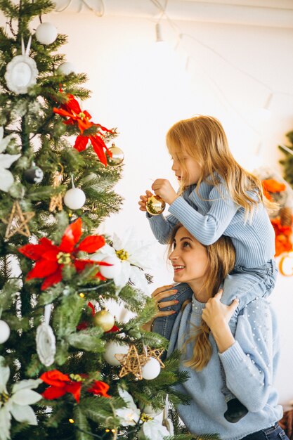 Mother with daughter decorating christmas tree