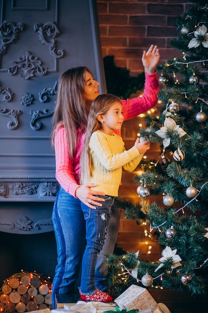 Mother with daughter decorating Christmas tree