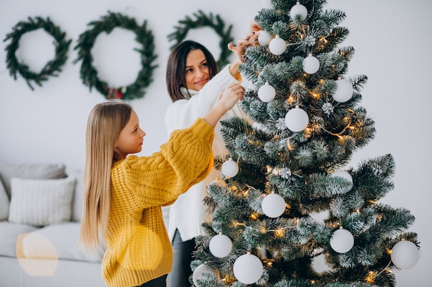 Mother with daughter decorating christmas tree