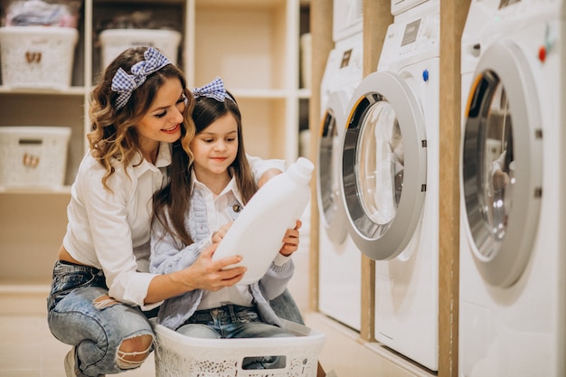 Free Photo mother with daughter doing laundry at self serviece laundrette