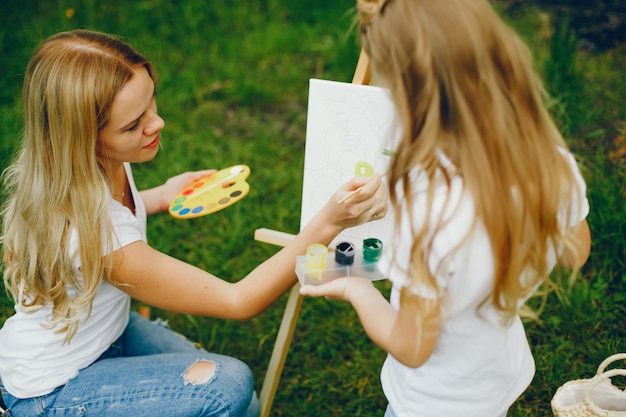 Free photo mother with daughter drawing in a park