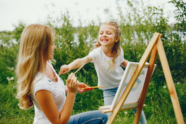 Mother with daughter drawing in a park