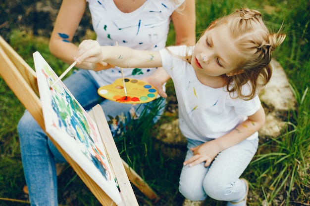 Mother with daughter drawing in a park