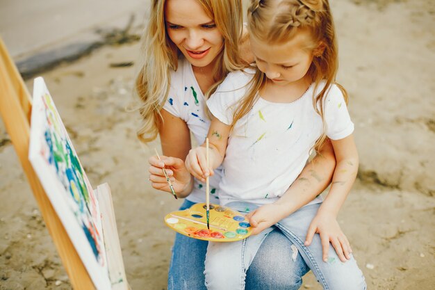 Mother with daughter drawing in a park