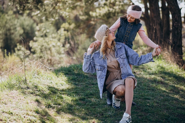 Mother with daughter having fun in the forest