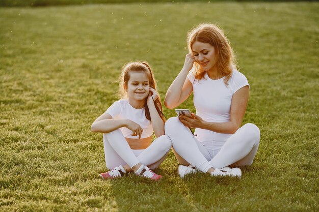 Mother with daughter listen a music in a park