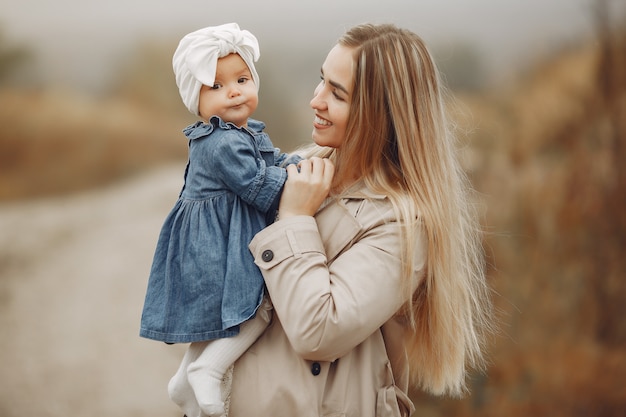 Mother with daughter playing in a autumn field