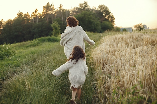 Mother with daughter playing in a summer field