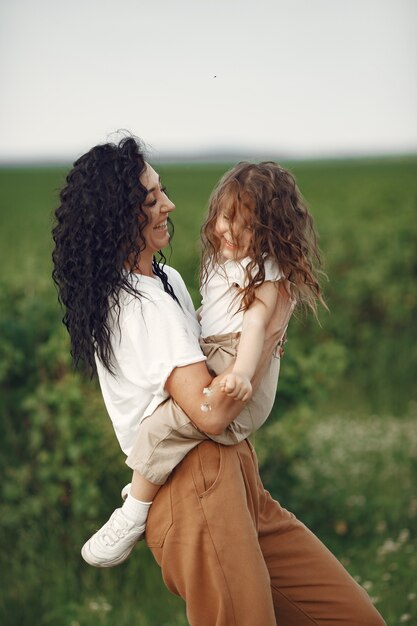 Mother with daughter playing in a summer field