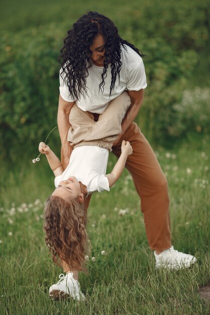 Mother with daughter playing in a summer field