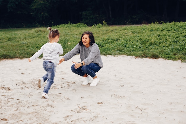 Mother with daughter playing in a summer park