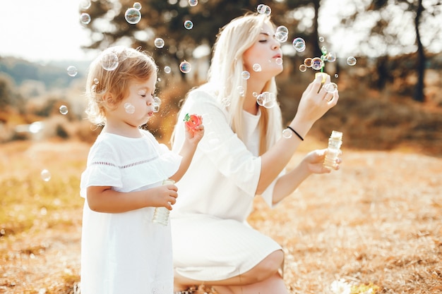 Mother with daughter playing in a summer park