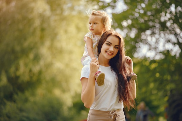 Mother with daughter playing in a summer park