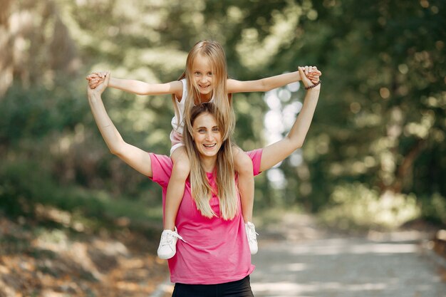 Mother with daughter playing in a summer park