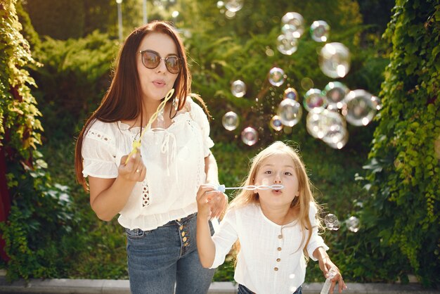 Mother with daughter playing in a summer park