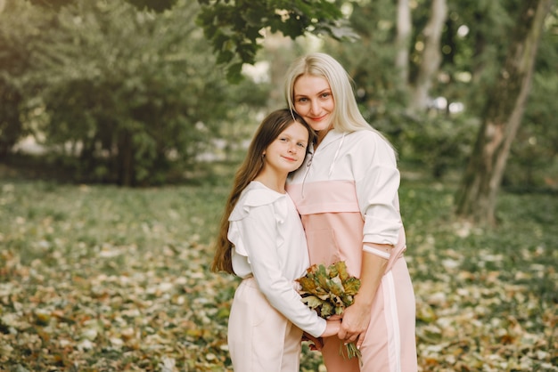 Free photo mother with daughter posing in a summer park