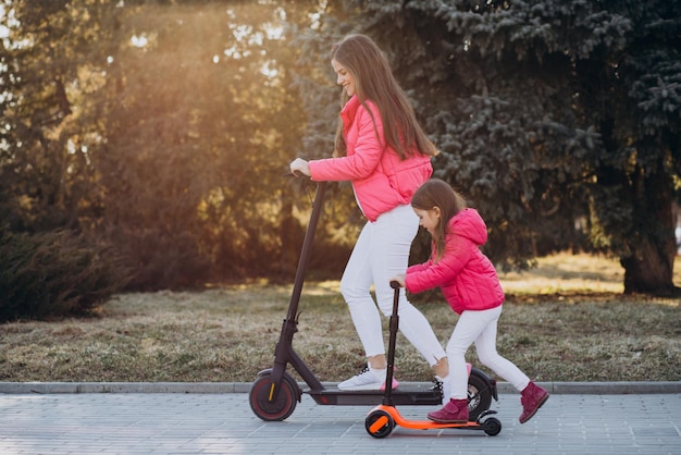 Mother with daughter riding electric scooter