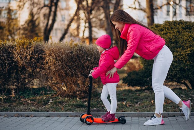 Mother with daughter riding electric scooter