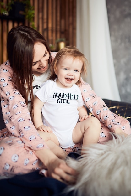 Free photo the mother with daughter sitting on the bed