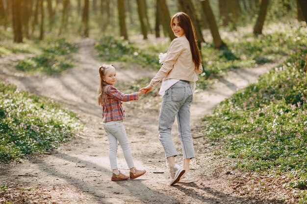 Mother with daughter in a spring forest with dog