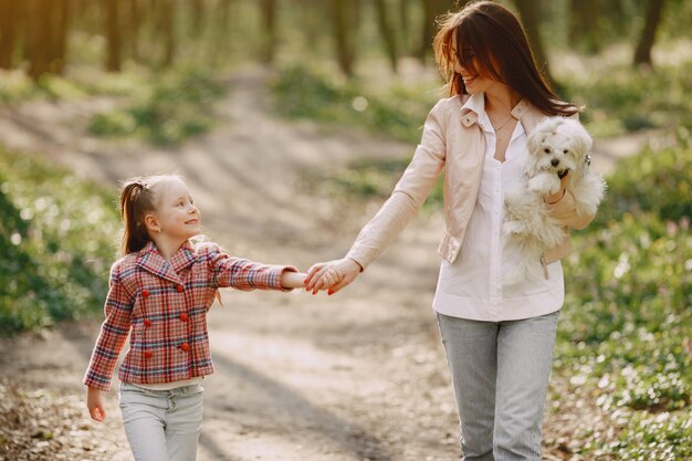 Mother with daughter in a spring forest with dog