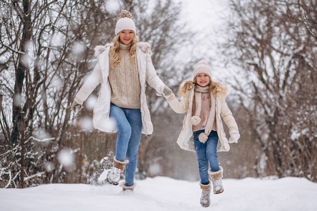 Mother with daughter walking together in a winter park