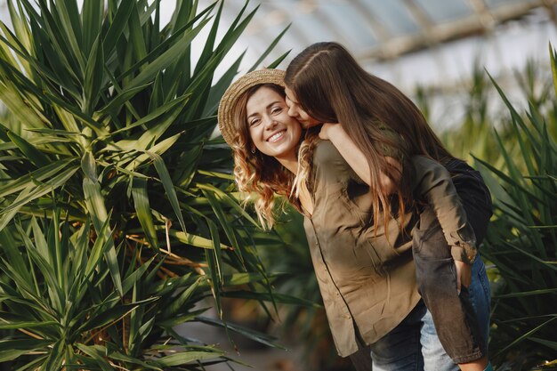 Mother with daughter. Workers with flowerpoots. Girl in a green shirt