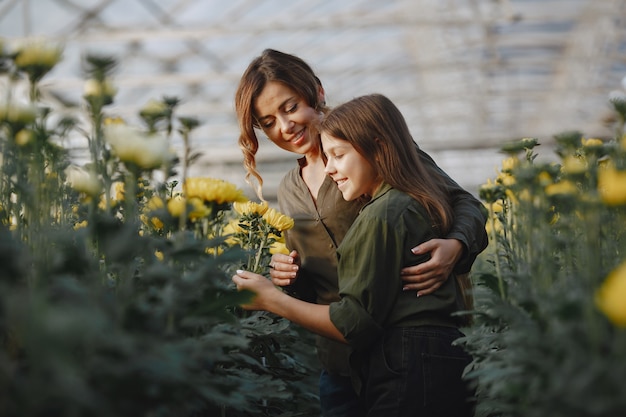 Free photo mother with daughter. workers with flowerpoots. girl in a green shirt