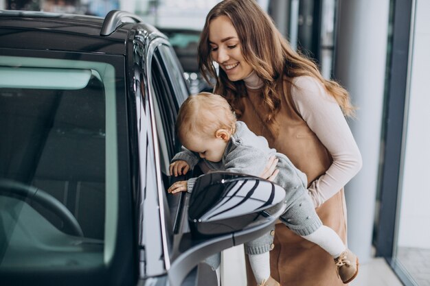 Mother with her baby daughter in a car showroom