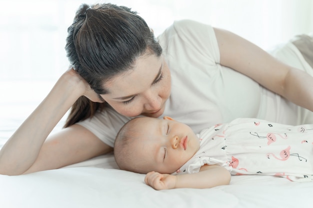 Mother with her baby sleeping on bedroom