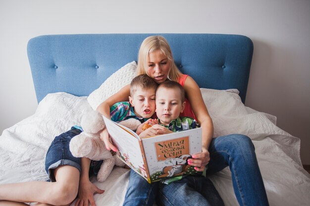 Free photo mother with her children reading a book