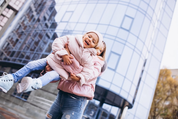 Free Photo mother with her little daughter dressed in warm cloth aoutside the street