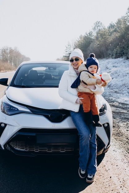 Mother with her little son by the car