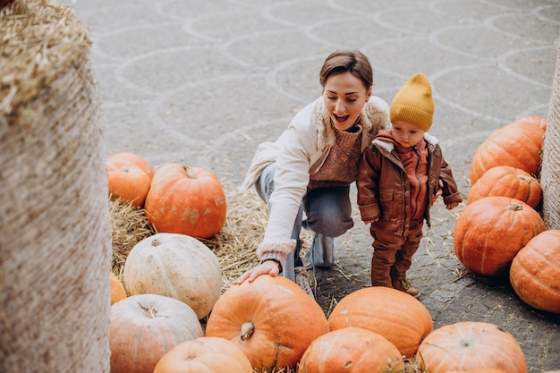 Free Photo mother with her little son by the pumpkins on halloween