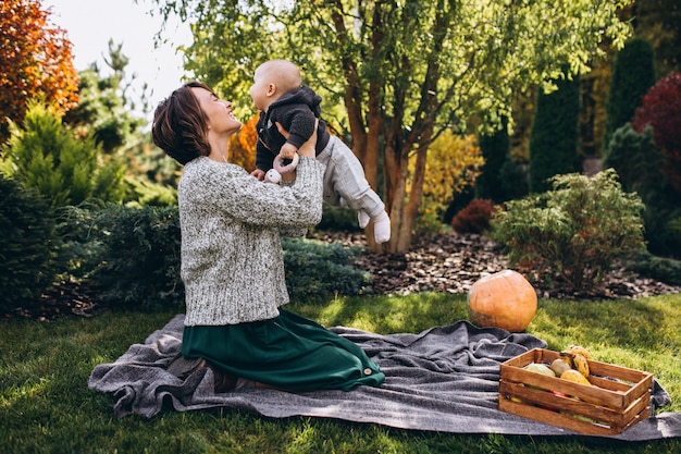 Free photo mother with her little son having picnic on a back yard