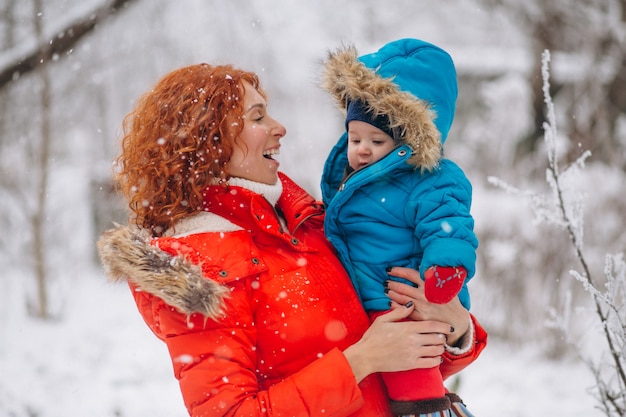 Mother with her little son together in a winter park