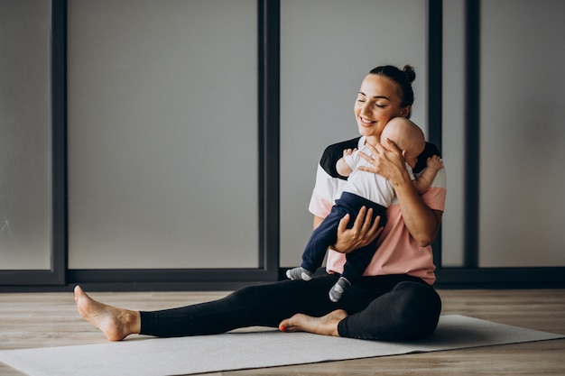 Mother with little baby boy practice yoga