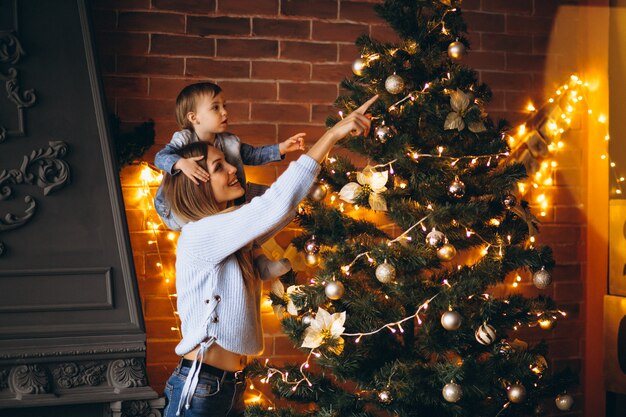 Mother with little daughter decorating Christmas tree