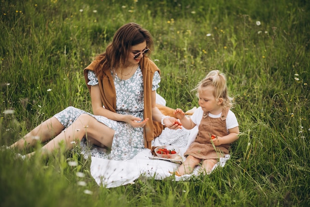 Mother with little daughter having picnic in park