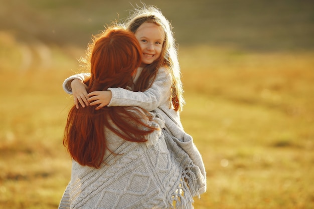 Free photo mother with little daughter playing in a autumn field