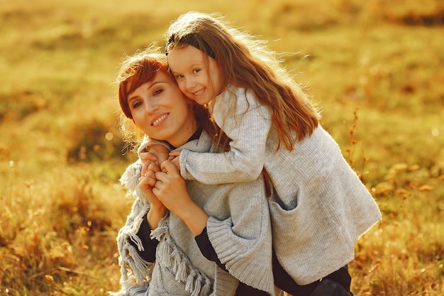 Mother with little daughter playing in a autumn field