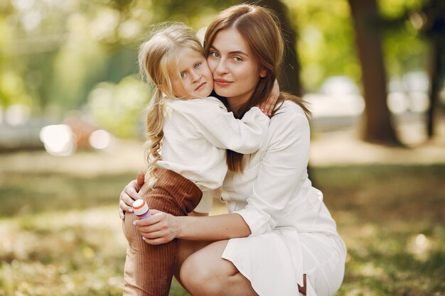 Mother with little daughter playing in a summer park